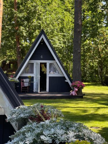 a small house with a teddy bear in a yard at Camping Milk in Usmenieki