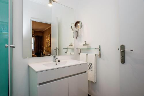 a bathroom with a sink, mirror, and bathtub at PH Downtown Suites in Lisbon