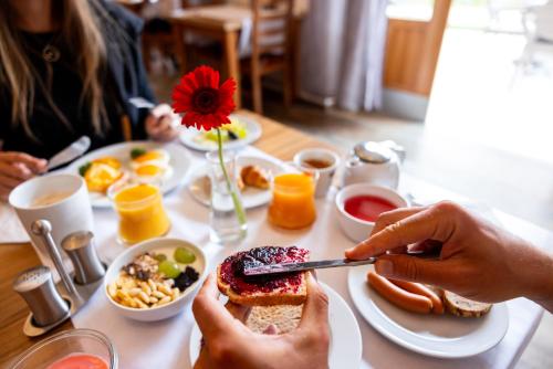a table with a plate of breakfast food on it at Pytloun Wellness Hotel Hasištejn in Místo