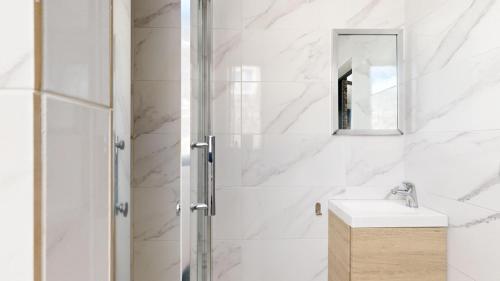 une salle de bain avec une douche, un lavabo et un miroir dans l'établissement Bluestay 11 - Charmant Studio au Cœur de Paris, à Paris