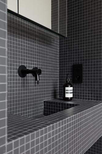 une bouteille de savon assise sur une étagère dans une salle de bains dans l'établissement Atelier Artiste, à Paris