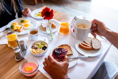 a person sitting at a table with a plate of breakfast food at Pytloun Wellness Hotel Hasištejn in Místo