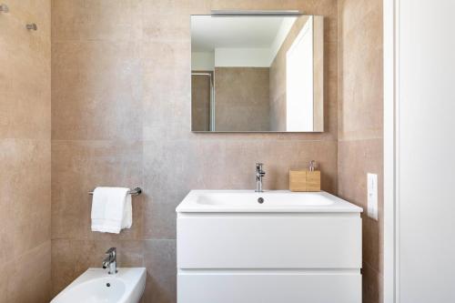 a bathroom with a white sink and a mirror at Regalia Suites - Free Parking in Lugano