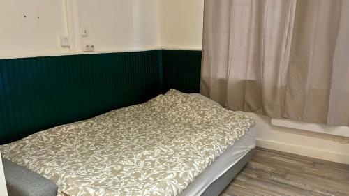 un lit dans une chambre avec un mur végétal dans l'établissement Appartement calme et cosy - Proche centre, à Rouen