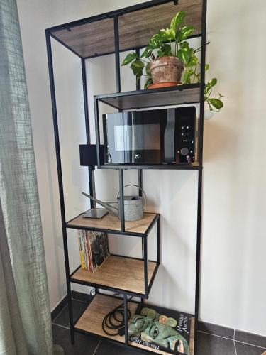 a black shelf with a microwave and some plants at Hippolyte - Magnifique appartement en centre-ville in Dijon