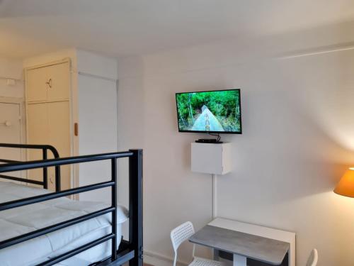 une pièce avec une télévision à écran plat sur un mur dans l'établissement chez Joseph, à Ville-dʼAvray