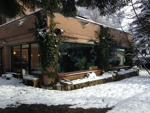 a building with snow on the ground in front of it at LH Albergo il Picchio in Pescasseroli