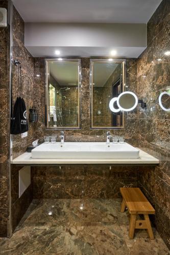 a bathroom with a large tub and a wooden stool at F&B Spa Resort (ex. Fomich Hotel) in Bukovel