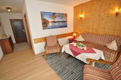 a living room with a couch and a table at Appartementhaus Alpenrose in Wallgau