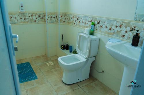 a bathroom with a toilet and a sink at Halisi Nyali Lux Apartments in Mombasa
