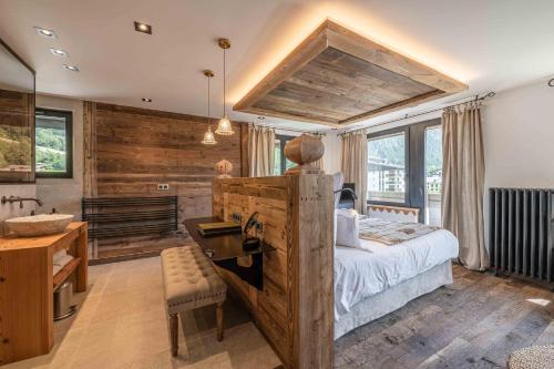 a bedroom with a bed and a desk and a sink at Chalet-Hôtel Hermitage in Chamonix-Mont-Blanc