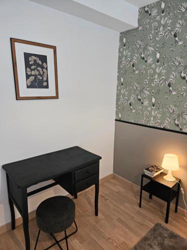 a black desk and a chair in a room at Hippolyte - Magnifique appartement en centre-ville in Dijon