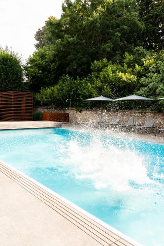 a swimming pool with a water fountain at Sweet Hotel in Longa