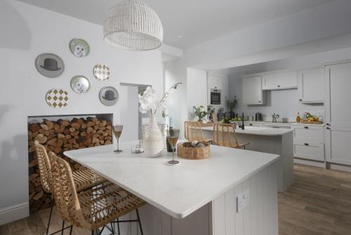 a white kitchen with a table and chairs at The Elms in Uny Lelant