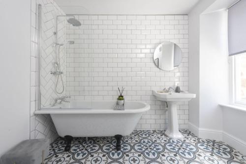 a white bathroom with a tub and a sink at The Elms in Uny Lelant