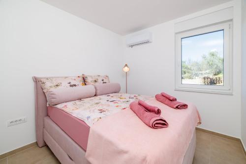 a bedroom with a pink bed with pink towels on it at Schmidt mali in Dramalj