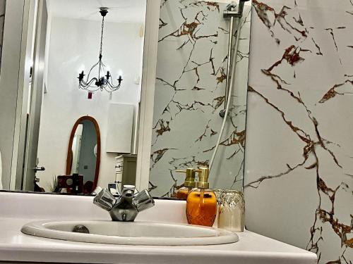 a bathroom sink with a mirror and a candle on it at Gold Hotel - Paris-Disney Studio in Chelles
