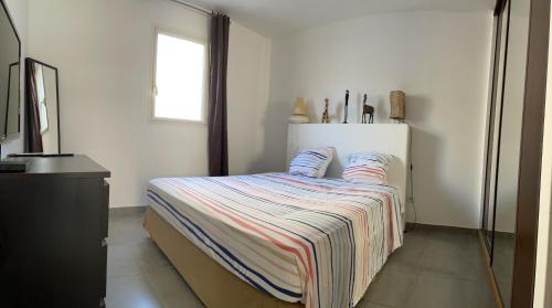 - une chambre avec un lit doté d'une couverture rayée dans l'établissement Appart avec Piscine privée proche Vélodrome et Metro, à Marseille