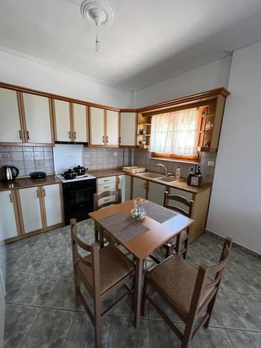 a kitchen with a table and chairs in it at Sunset Seaview Apartment in Ladochórion