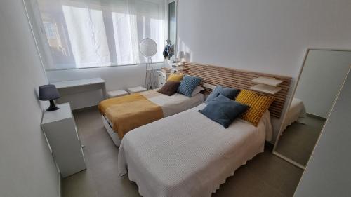 een slaapkamer met twee bedden en een raam bij SolDosMares Apartmentos in La Manga del Mar Menor