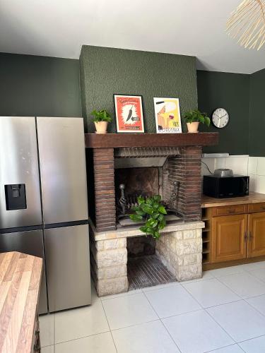 a kitchen with a brick fireplace in a kitchen at Chambres d'hôte & Gîte Château Le Conte - Saint Emilion in Saint-Émilion