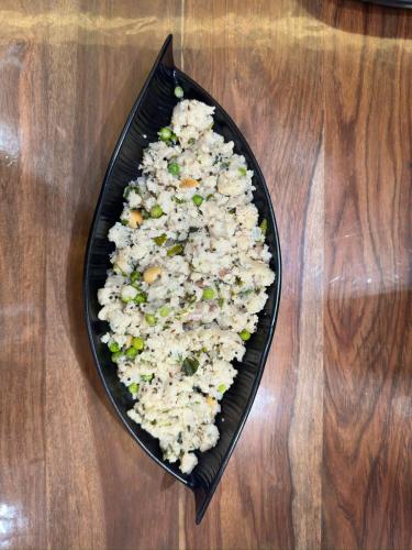 a plate of rice and vegetables on a wooden table at Dolce Villa IGATPURI in Igatpuri