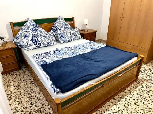 a bed with blue and white pillows on it at Ferienwohnung mit 2 Schlafzimmern, Strandnähe & voll ausgestattet in Néa Karváli