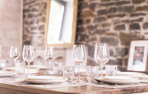 - une table avec des verres à vin et des assiettes dans l'établissement L'Olivera : entre évasion, sport et nature, à Barneville-Carteret