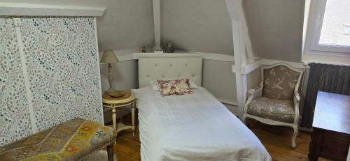 une petite chambre avec un lit et une chaise dans l'établissement La Cour Du Puits Chambre Victor, à Cormeilles