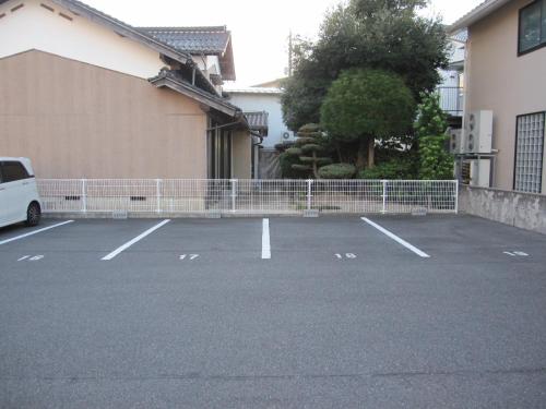 a parking lot with a white van parked next to a building at ゲストハウス あずも GuestHouse AZMO in Matsue