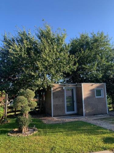 a small house with a tree in a yard at Cantinho de Trevoeiros - Casa Duarte in Arcos de Valdevez