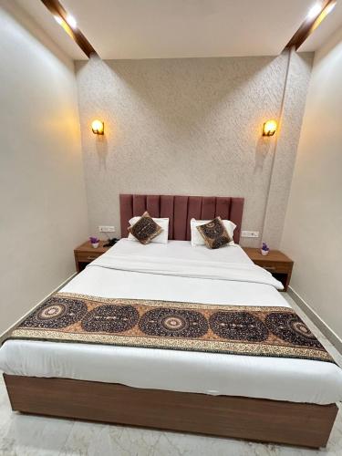a bedroom with a bed with two pillows on it at Hotel Satsang Grand in Varanasi