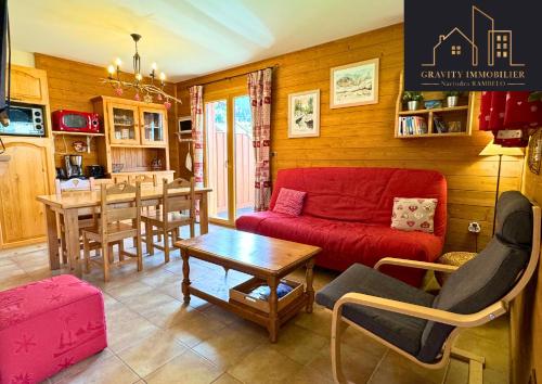un salon avec un canapé rouge et une table dans l'établissement CHALET duplex Mont-Saxonnex 