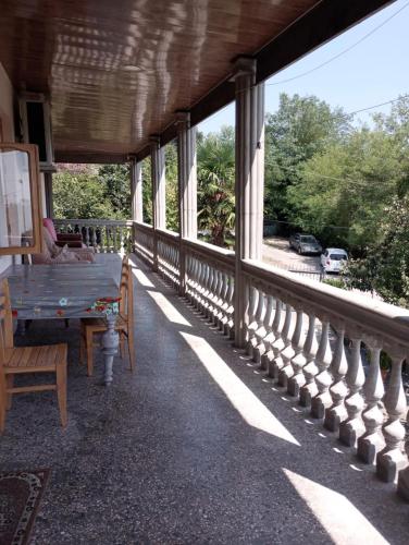 a porch of a house with a table and chairs at Tskaltubo Guesthouse Oda in Tskaltubo