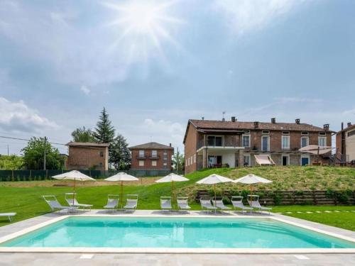 a swimming pool with chairs and umbrellas at Il Sogno di Elisa Country House in Calosso