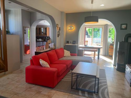 un salon avec un canapé rouge et une table dans l'établissement Maison à 10 mn de Paris, à Juvisy-sur-Orge