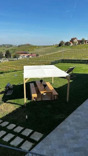 a picnic table under a white tent in a field at Il Sogno di Elisa Country House in Calosso
