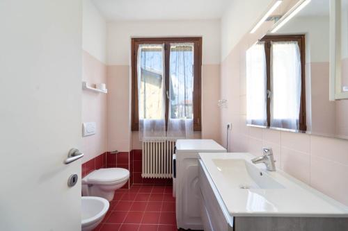a bathroom with a white toilet and a sink at Dolce Far Niente Apartment - Lake Como in Colico
