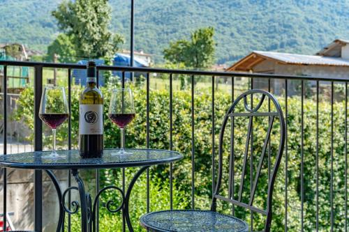 a table with two glasses of wine on a balcony at Dolce Far Niente Apartment - Lake Como in Colico