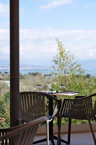 a table and chairs on a balcony with a view of the ocean at Thalazur Antibes - Hôtel & Spa in Antibes