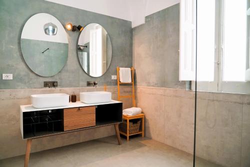 a bathroom with two sinks and a mirror at Palazzo 922 - ELEGANZA nel CUORE della CITTA' BIANCA in Ostuni