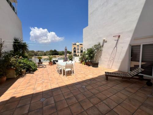 a patio with a table and chairs on a building at Carousel Apartments in Qrendi