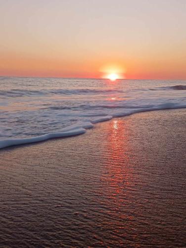 a sunset on a beach with the ocean at Sunset in Rodhiná