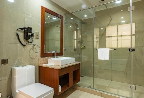 a bathroom with a shower and a sink and a toilet at Hermosa Garden Hotel in Nairobi