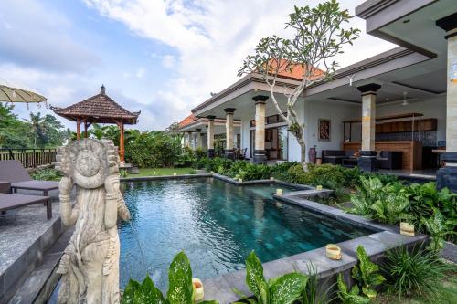 a swimming pool in a villa with a garden at Griya Private Villa in Ubud