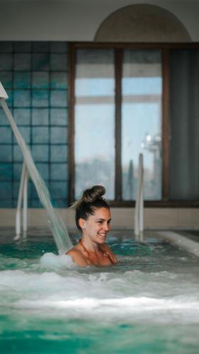 a woman is swimming in a swimming pool at Sofitel Golfe d'Ajaccio Thalassa Sea & Spa in Ajaccio