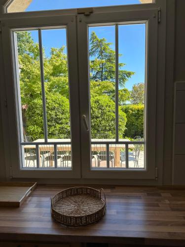 a room with three windows and a basket on a wooden floor at Chambres d'hôte & Gîte Château Le Conte - Saint Emilion in Saint-Émilion