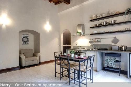a kitchen and living room with a table and chairs at Calzaiuoli Apartments by Mamo Florence in Florence