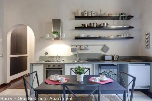 a kitchen with a table and chairs in a kitchen at Calzaiuoli Apartments by Mamo Florence in Florence