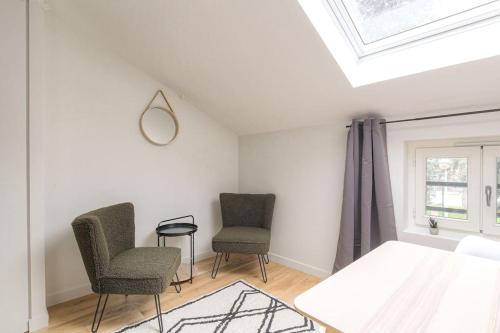 - une chambre avec deux chaises, un lit et une fenêtre dans l'établissement Studio neuf, clim et parking, Cité Internationale, à Caluire-et-Cuire